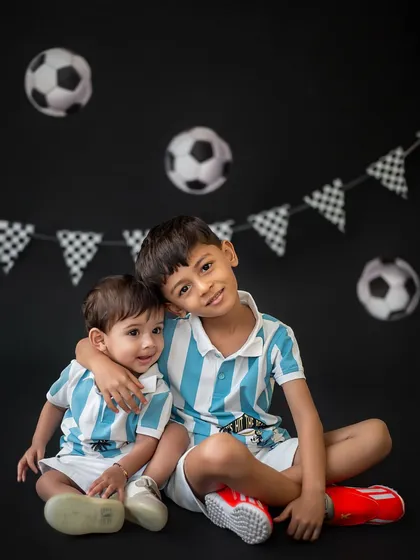 For the little superstars in your family, a themed shoot is a perfect way to capture their passions. These two brothers, dressed in matching football jerseys, show off their team spirit and adorable bond.
