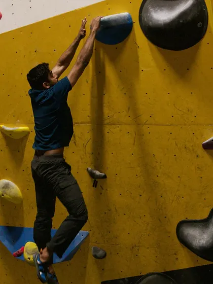 A climber latches onto a hold, demonstrating the strength and body tension needed to complete a dyno. Our sessions focus on the technique behind these impressive moves.