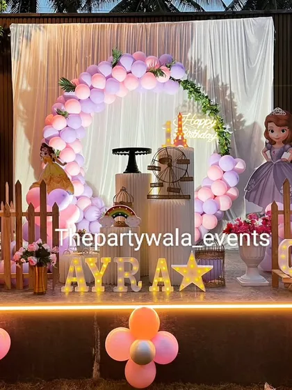 A beautiful outdoor setup for a Sofia the First princess party. The decorations look wonderful in the natural light, and the stage is perfect for photos and cake cutting.
