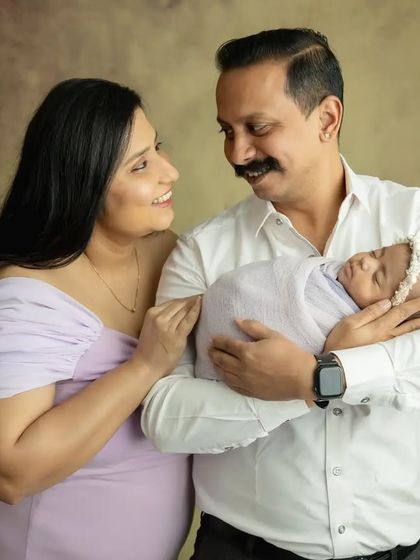 A candid moment between the parents as they lovingly gaze at their newborn daughter.