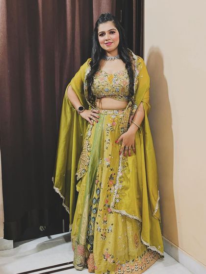 A full look of our client in the olive green floral lehenga. It's a perfect outfit for any festive occasion.