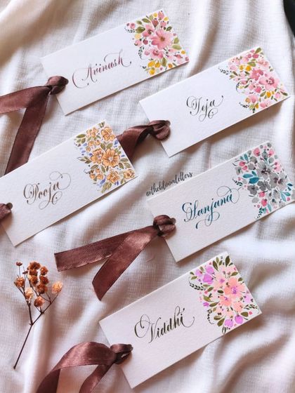 A closer look at the hand-painted and calligraphed name tags I created for my teachers, each with a unique floral design.