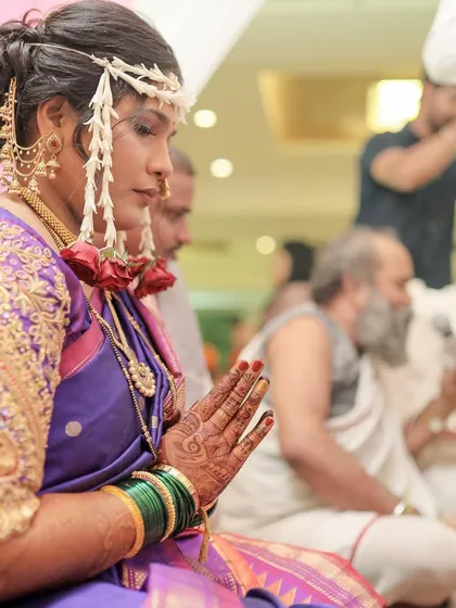 A side profile showing the intricate details of the bridal hairstyle and the placement of the Mundavalya (forehead jewelry).