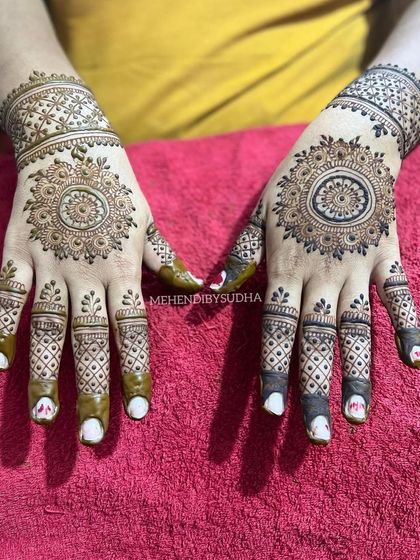 A beautiful mandala design on the back of the hands with intricate check-patterned finger details.