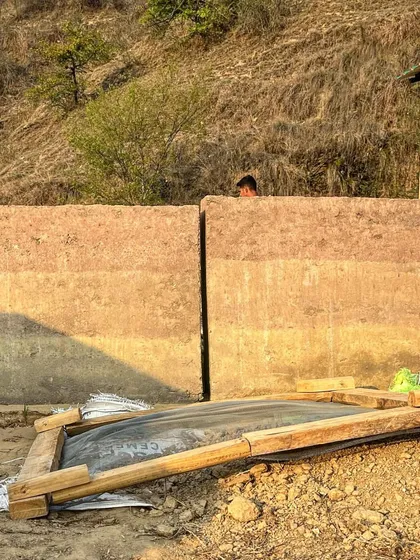 Freshly cast rammed earth walls at a project site in Almora. The different layers of earth create a natural, stratified pattern, showcasing the beauty of this sustainable building technique.