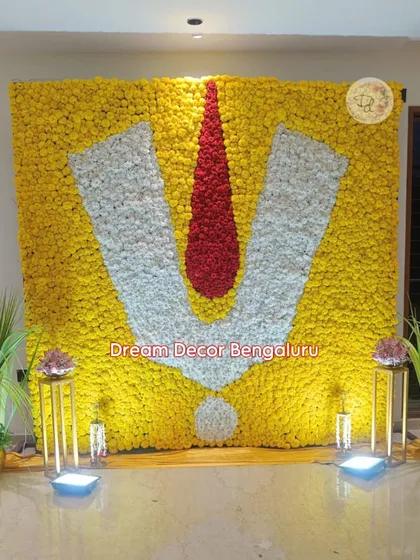 This backdrop for a Satyanarayana Pooja is a testament to how flowers can create powerful symbols. We used thousands of yellow, white, and red flowers to form this massive, auspicious namam, creating a truly divine focal point.