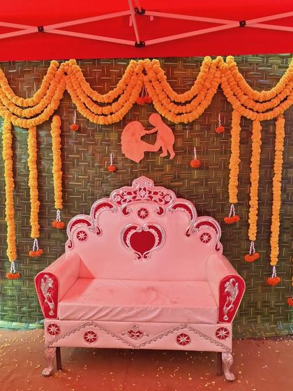 A closer view of the traditional woven mat backdrop, showing the texture and the simplicity of the marigold flower arrangement.