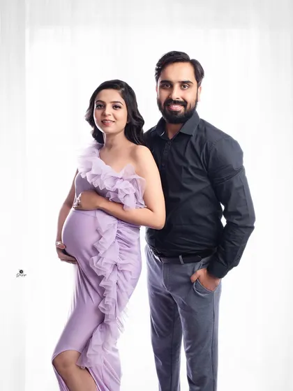 A lovely, classic couple portrait against a bright, airy background. The client's lavender gown and her partner's simple dark shirt create a beautiful, clean look.