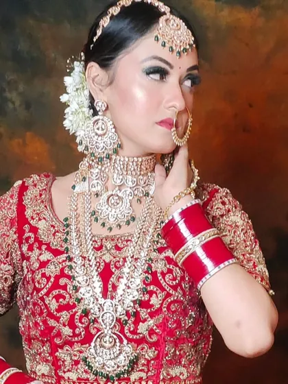 A bride wearing a layered green and white Kundan set with a red lehenga. The combination of colors and layers creates a rich and dynamic look.