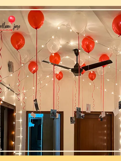 I love turning memories into part of the decor. This simple yet powerful setup uses helium balloons to float your favorite photographs from the ceiling, surrounded by the warm glow of fairy lights for a truly personal and romantic atmosphere.
