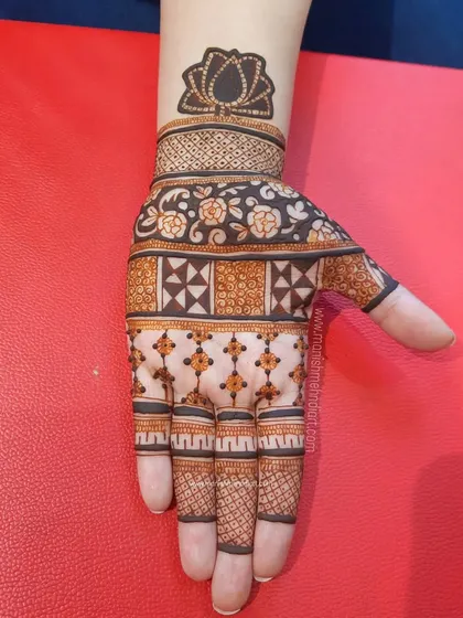 This geometric design is perfect for the modern bride. It uses clean lines, squares, and floral patterns to create a structured yet beautiful look, with a lotus motif at the top.