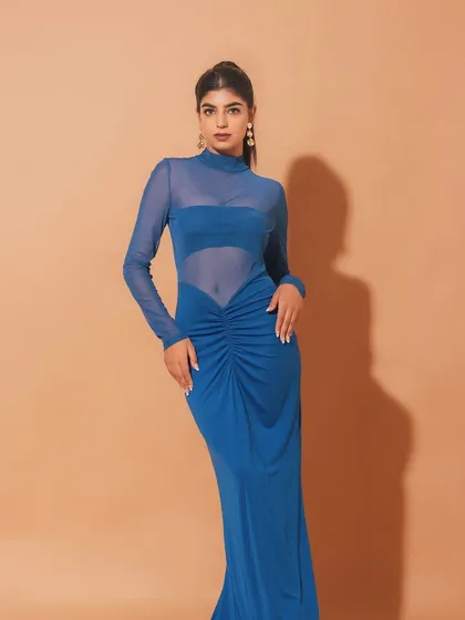 A full-length shot of the elegant blue gown. The makeup is sophisticated and understated, ensuring the focus remains on the dress and the model's graceful pose.
