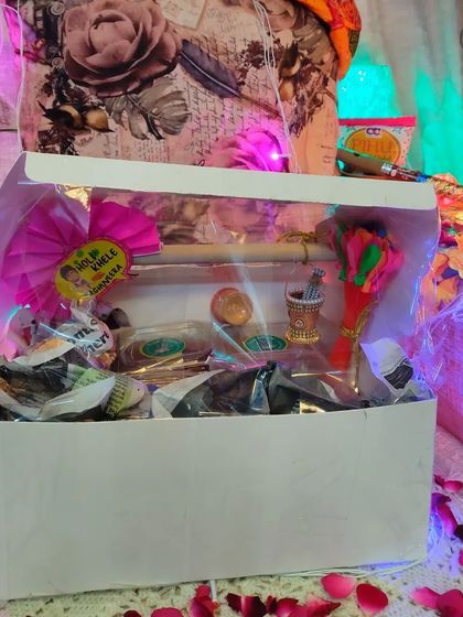 A beautifully styled shot of a Holi hamper box, decorated with flower petals and fairy lights, ready for gifting.