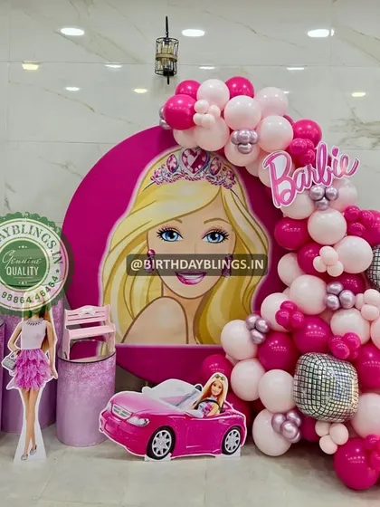 Another angle of the Barbie setup with the large character backdrop, showing the full balloon garland and themed plinths.