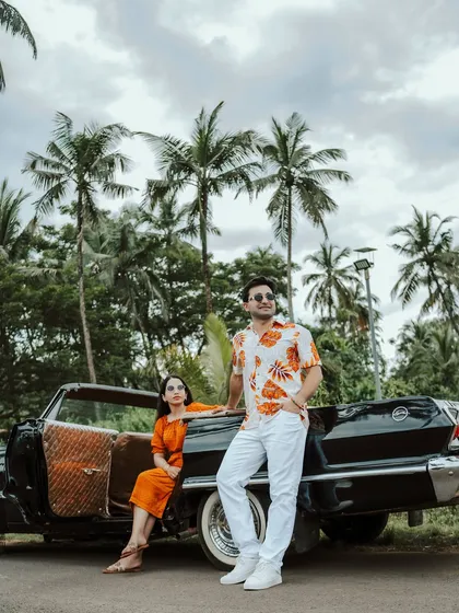A fashion-forward pose with the vintage car, showcasing the couple's style against the lush Goan scenery. This demonstrates my ability to direct and capture magazine-worthy shots.