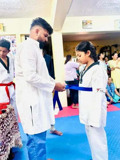 Another student proudly receives her blue belt.