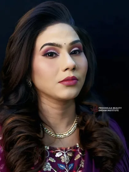 Celebrating defined curls and a glamorous makeup look. The voluminous hair is paired with a striking pink and purple eye, creating a look that is both bold and beautiful.