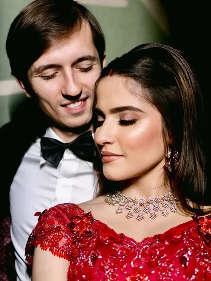 A close-up of a timeless reception look. The focus here is on flawless skin, soft yet defined eyes, and a classic red lehenga, creating a moment of pure elegance and modern romance for the new bride.