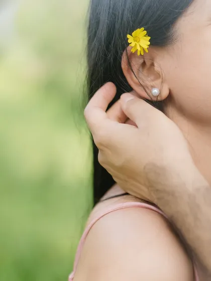A delicate detail shot of a flower tucked behind her ear. It’s these small, romantic details that add a layer of poetry to a pre-wedding collection.