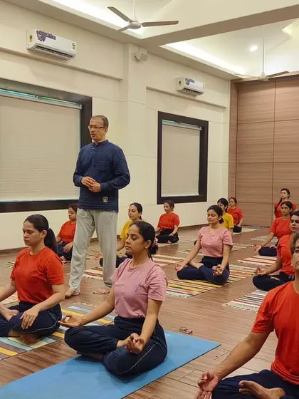An instructor provides guidance during a group meditation session. Our classes maintain a focus on individual awareness even in a group setting, ensuring each practitioner receives the attention needed for correct and safe practice.