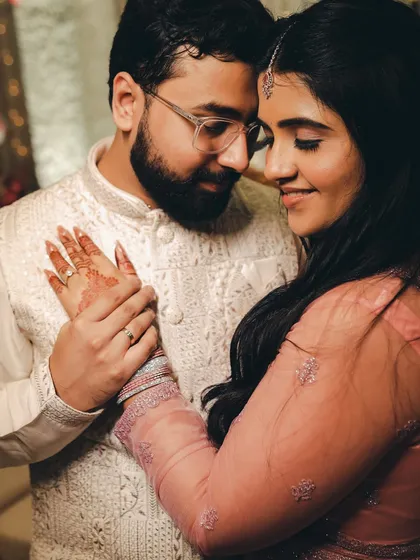 An intimate close-up of the couple, their hands intertwined. The soft lighting and their gentle expressions create a feeling of warmth and deep affection.