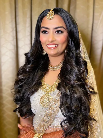 A vision of grace in white and gold. Bansi's wedding day makeup was all about soft, warm tones to create an angelic glow.