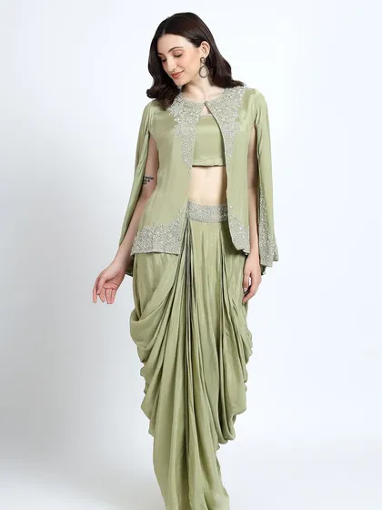 A mint green draped dhoti set with an embellished cape, a chic and contemporary option for a festive event.