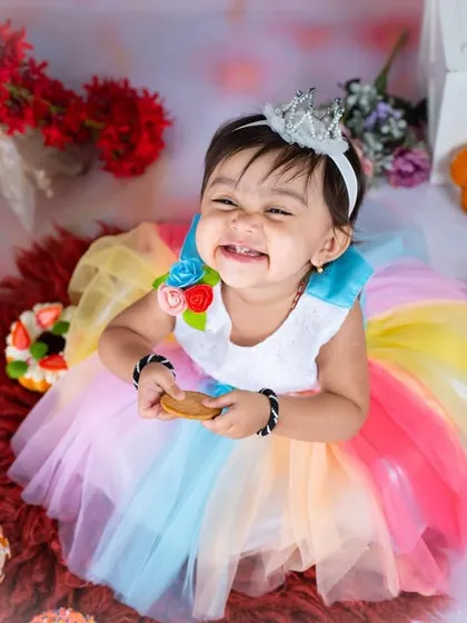 A huge, happy grin from our cookie princess. Her joy is absolutely contagious in this fun and colorful setup.