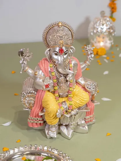 A closer look at the divine craftsmanship of our colored Ganesh idol. The intricate details on the crown and garments, combined with the serene expression, make it a truly special piece for your home.