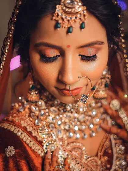 A detailed portrait showcasing the bride's eye makeup and heavy kundan necklace.