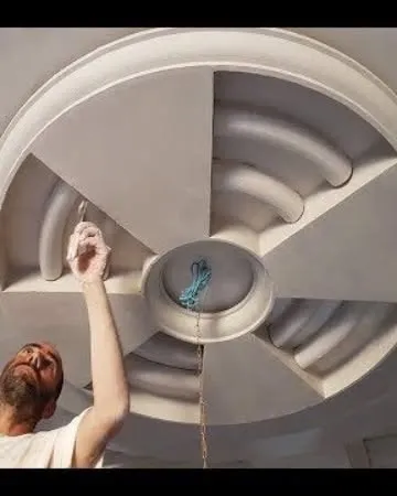 A worker is giving the final touches to a circular POP ceiling design. This hands-on finishing work is what guarantees a flawless result.