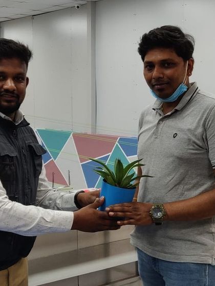 A coach presenting a plant to a participant during one of our academy events.