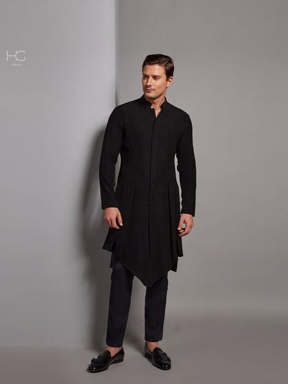 Bold in black. This Indo-Western kurta features a dramatic, asymmetrical hemline, offering a modern and edgy take on traditional menswear.