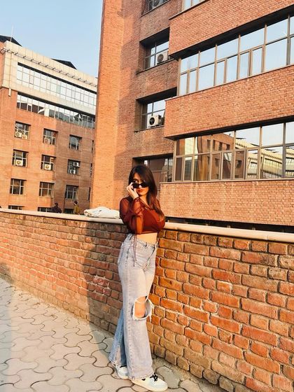 Adding sunglasses to the sheer top and jeans look. This shows how a simple accessory can change the whole mood of an outfit.