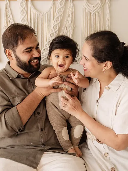 A close-up of the family interacting with their baby. The focus is on their expressions of love and happiness.