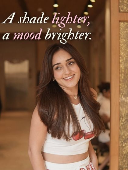 Main character energy only. A happy client showing off her fresh, glossy hair, embodying the confident and bright mood of the salon.