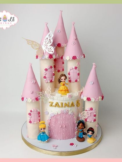 A grand princess castle cake for a 5th birthday. This pink and white castle features Princess Belle and her friends, with delicate butterfly and floral details for a magical touch.