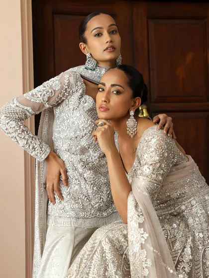 A closer shot highlighting the intricate silver and white embroidery of the outfits. My styling direction focused on clean hair and makeup to let the detailed craftsmanship of the garments shine.