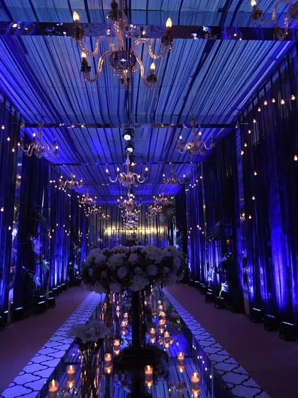 A study in blue. This royal blue-themed entrance featured dramatic draping, elegant chandeliers, and a mirrored walkway, reflecting the light to create an endless, enchanting path for guests.