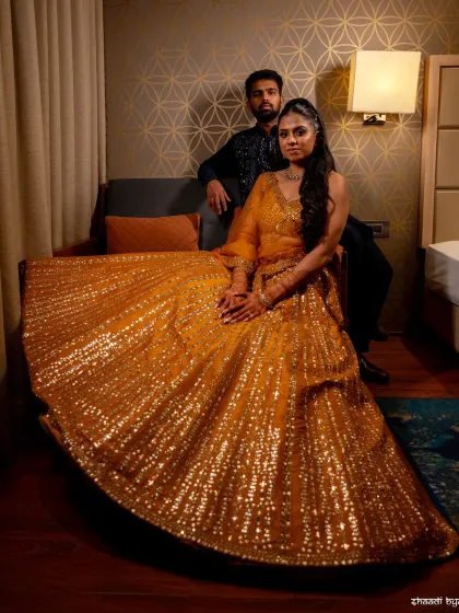 A full-length shot showcasing the bride's stunning, glittering lehenga. This is a great way to capture the details of the wedding fashion.