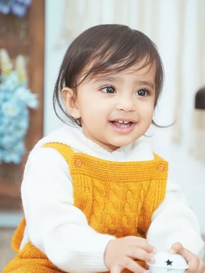 A handsome little boy in a cozy knit jumper, ready for his first birthday photos.