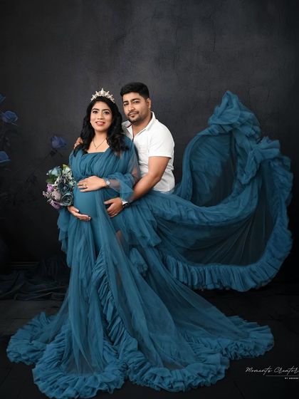 A beautiful couple's portrait in matching tones. The deep teal gown and the partner's embrace create a sense of harmony and romance in this dramatic shot.