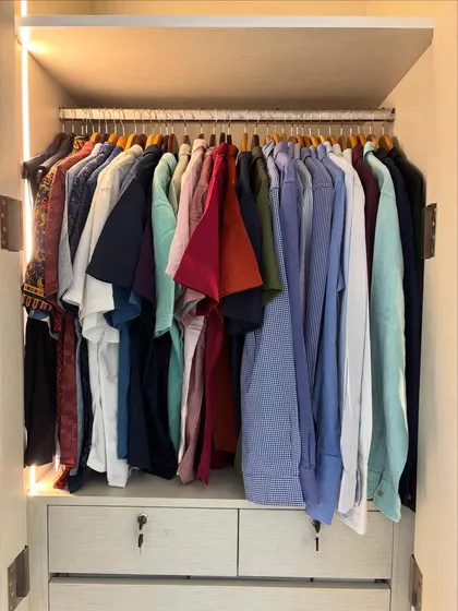This is a great example of a simple, effective system for a men's wardrobe. By organizing shirts by color and type, getting ready becomes a quick and stress-free process.