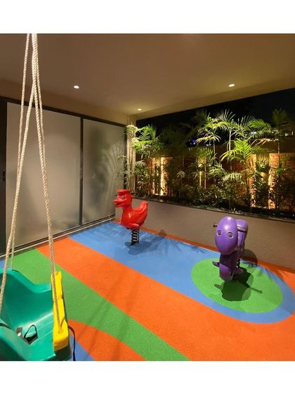 The toddler play area at night, with soft lighting and a backdrop of lush plants, creating a secure and inviting space for the youngest residents.