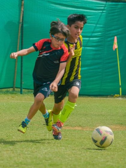 Two players are locked in a tight battle for ball possession, a common sight in our competitive Pride Cup matches.