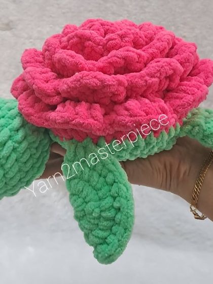 A 10-inch rose turtle made with plush yarn. The shell is crafted to look like a big pink rose, and the body is a cheerful green.