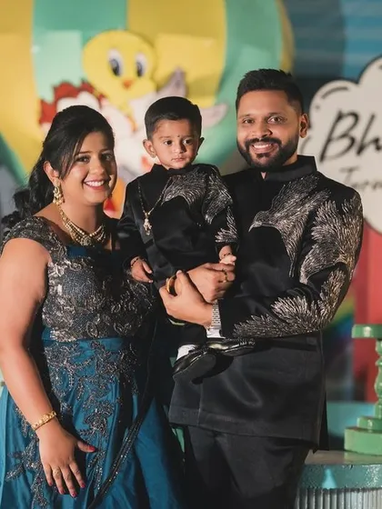 A happy family portrait of Bhuvik and his parents at his Looney Tunes first birthday party.