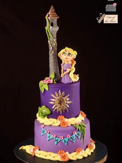 A beautiful two-tier Rapunzel cake in purple, featuring her tower, braided hair, and the magical sun crest.