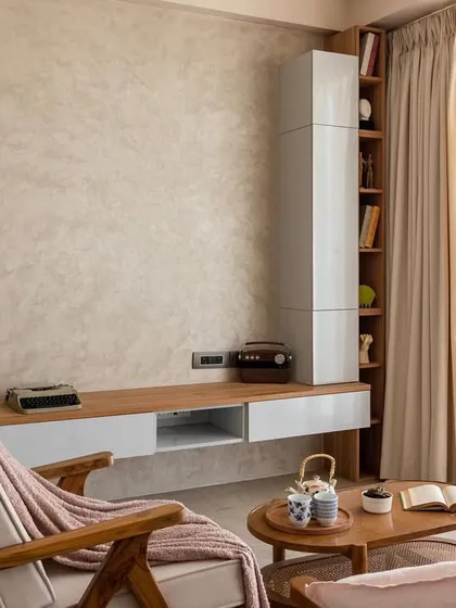 We love the understated beauty of a nude color palette. This view shows the TV unit with its textured wall and vertical wooden slats, adding depth and interest without overwhelming the space.