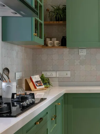 A closer look at the details in this green kitchen. The brushed brass handles add a touch of warmth against the cabinetry, and the open wooden shelf is perfect for keeping everyday cookbooks and spices within easy reach.